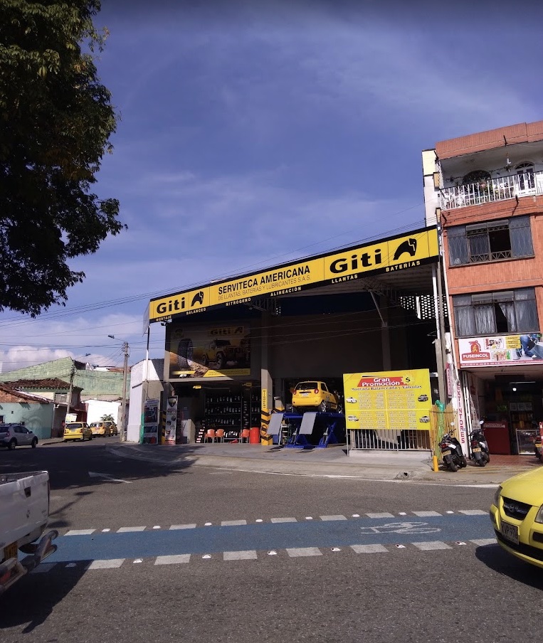 Fachada de la Serviteca Americana con el aviso amarillo, en la Carrera 23 de Bucaramanga